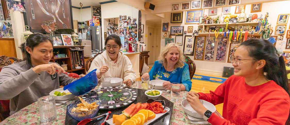 Homestay mum sharing meal with her international students