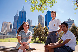 three students sitting in the park on a sunny day